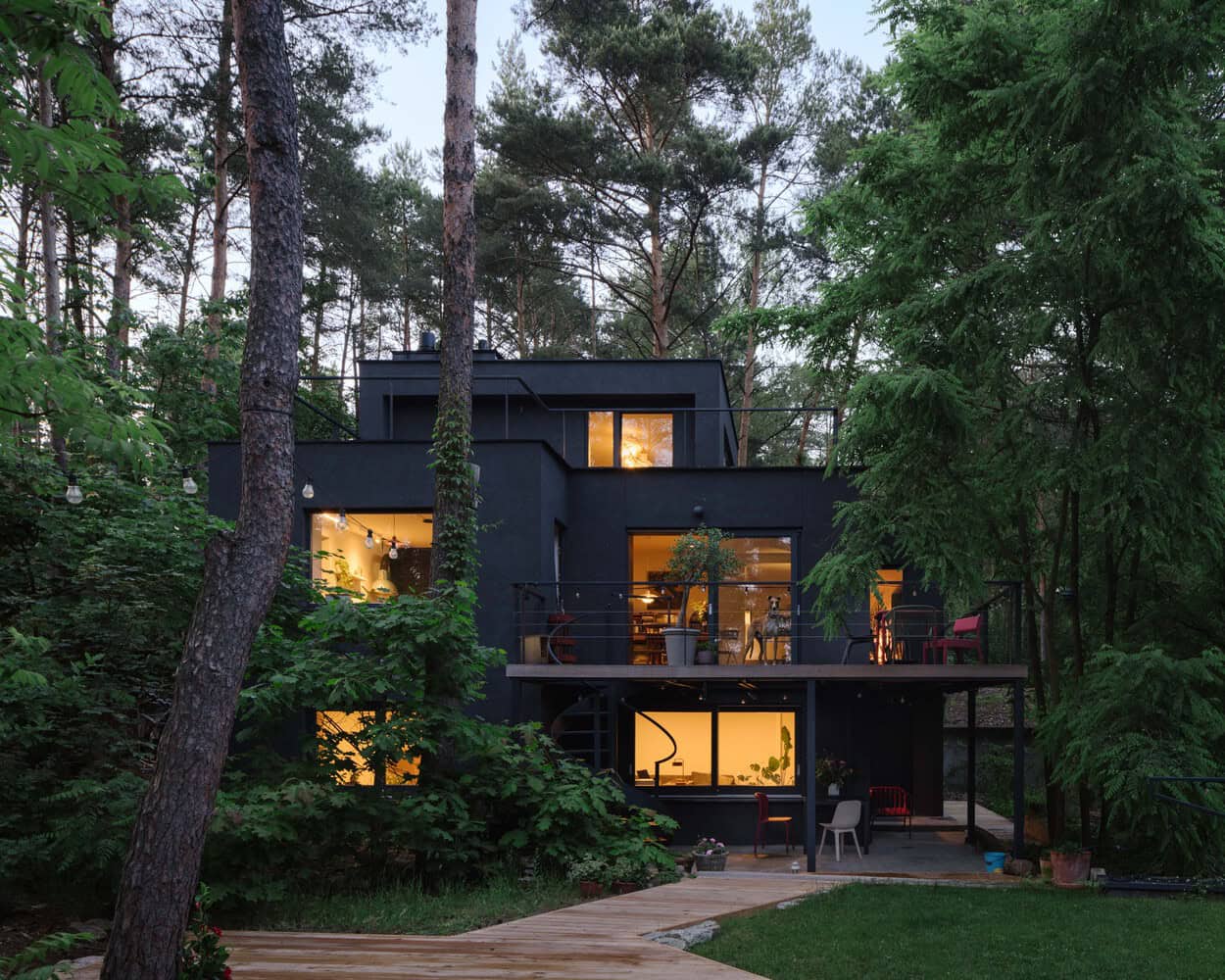 Rear two-storey facade of Skubianka House by SZCZ Jakub Szczesny surrounded by forest in Skubianka