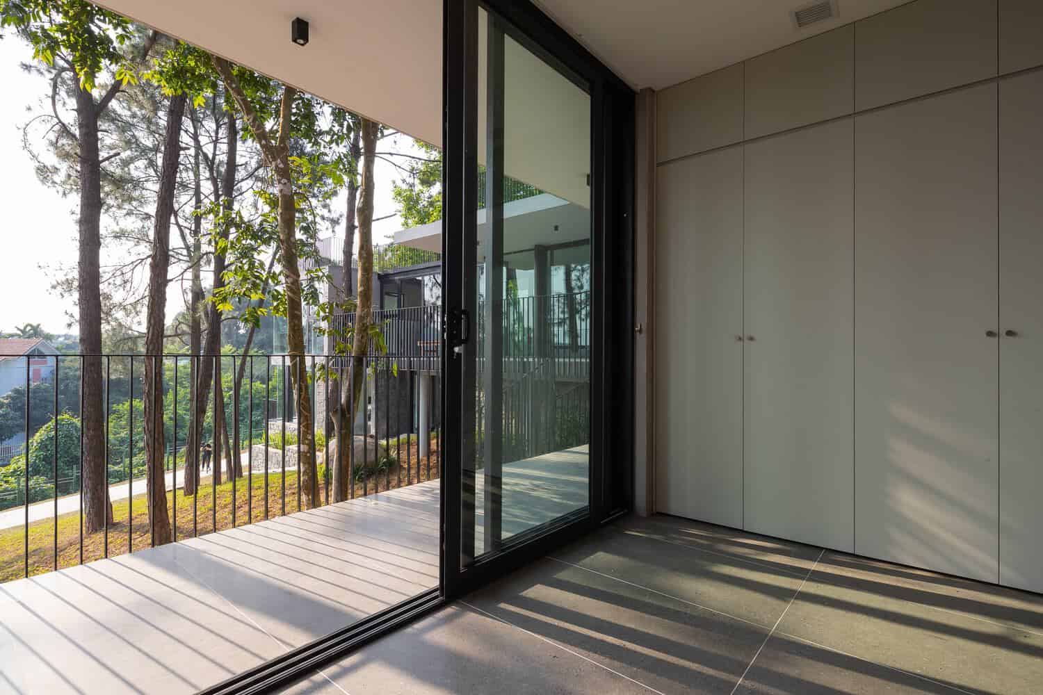 Tam Dao Retreat House by Idee architects bedroom balcony with slender railings facing forest in Tam Dao, Vietnam