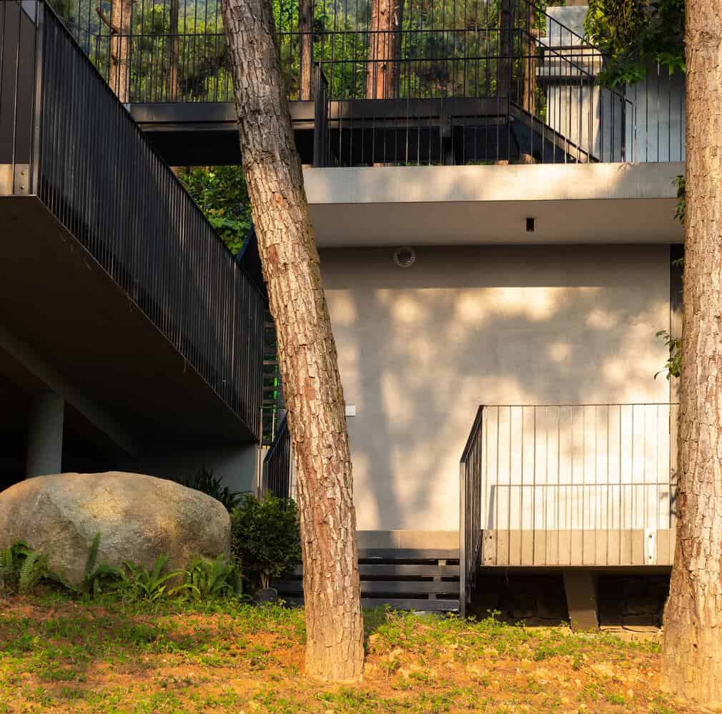 Tam Dao Retreat House by Idee architects entrance terrace with sunlit facade in Tam Dao, Vietnam