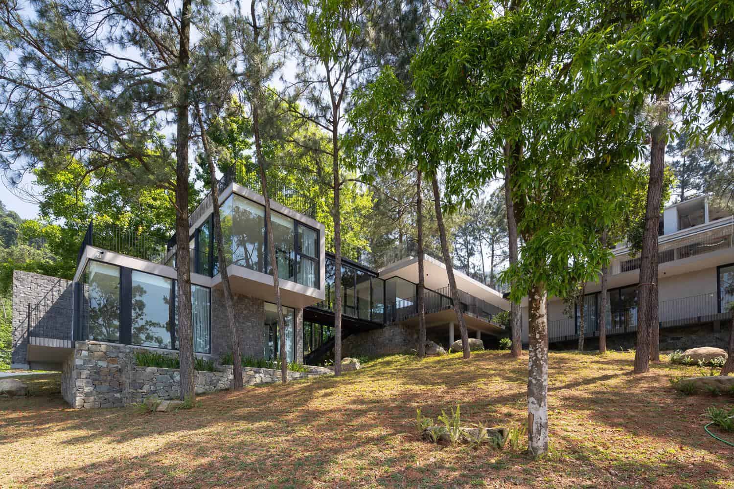 Tam Dao Retreat House by Idee architects glass and stone facade on forest hillside in Tam Dao, Vietnam