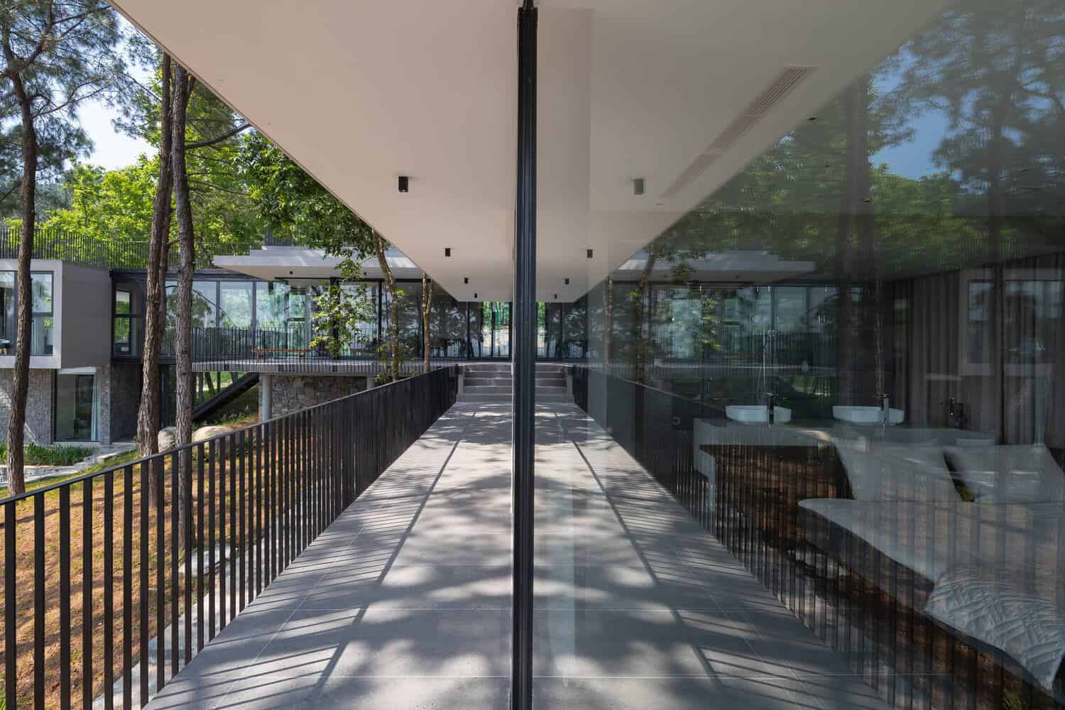 Tam Dao Retreat House by Idee architects elevation screened by pine forest in Tam Dao, Vietnam