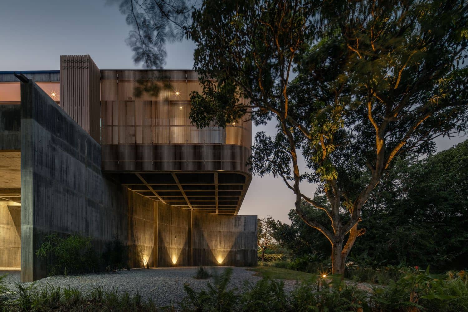 Cantilevered upper volume of W House II by IDIN Architects at dusk in Thailand