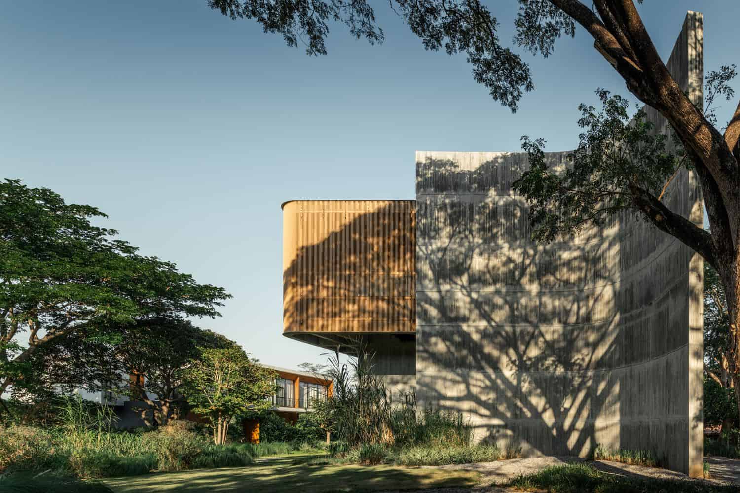 Curved concrete end wall of W House II by IDIN Architects in Thailand