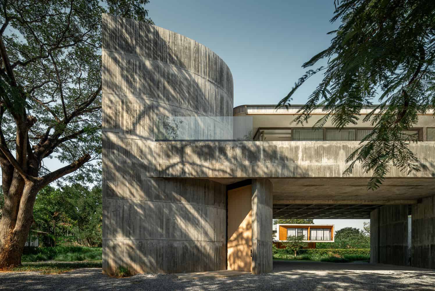 Curved concrete entry wall of W House II by IDIN Architects in Thailand