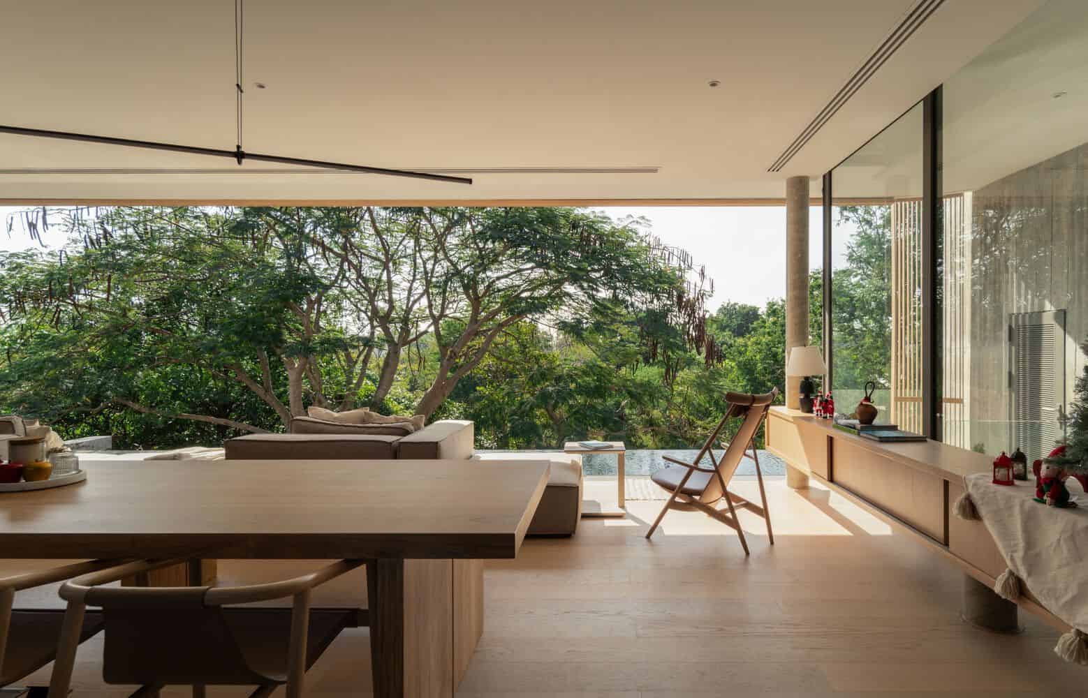 Dining area in W House II by IDIN Architects opening to terrace with forest view in Thailand