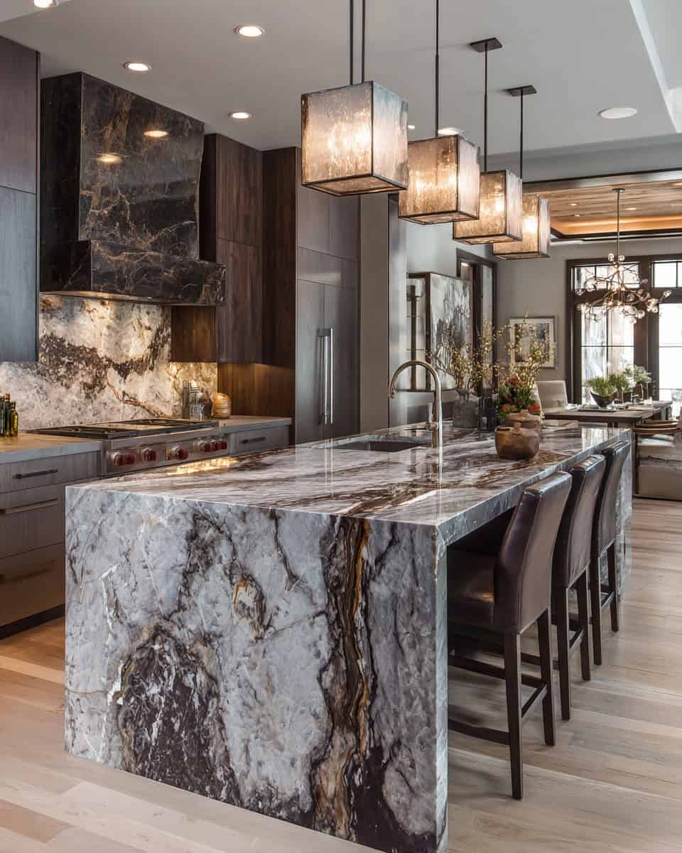 Modern kitchen with bookmatched marble waterfall island and artistic stone hood