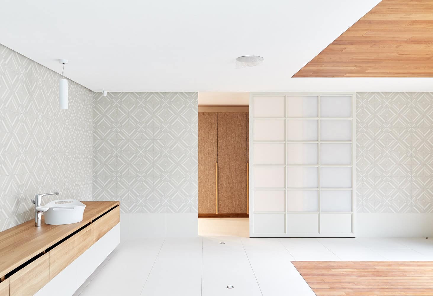 Minimalist bathroom at Villa Vista by Znameni Ctyr Architekti in Prague with wood vanity and textured wall tiles