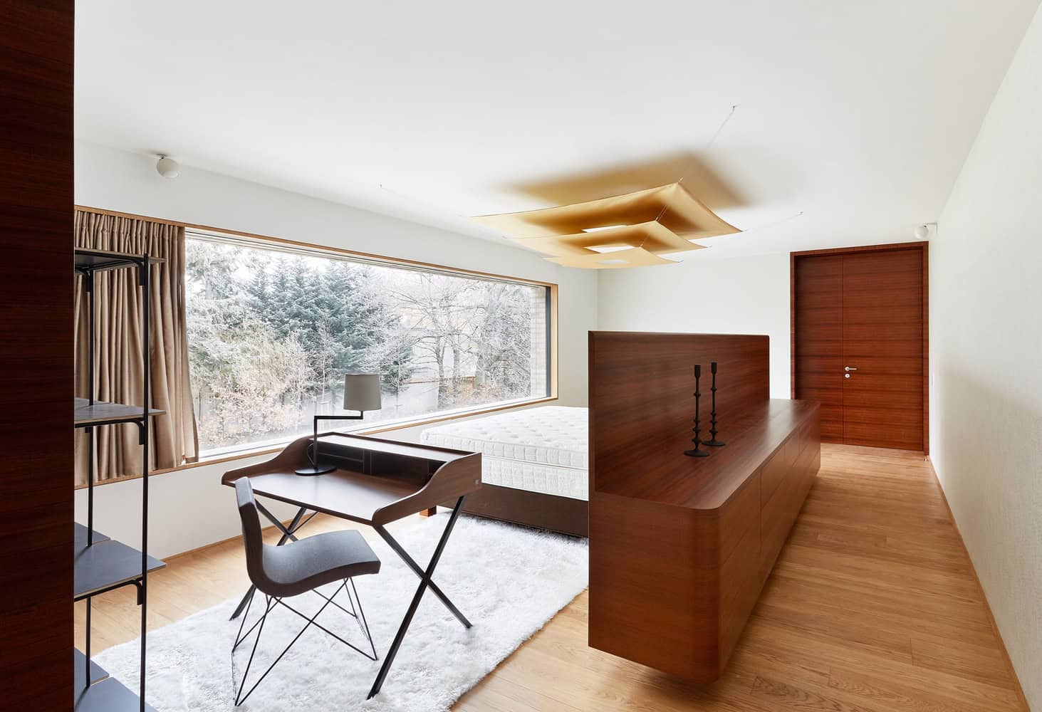 Bedroom at Villa Vista by Znameni Ctyr Architekti in Prague with a desk and panoramic window to the trees