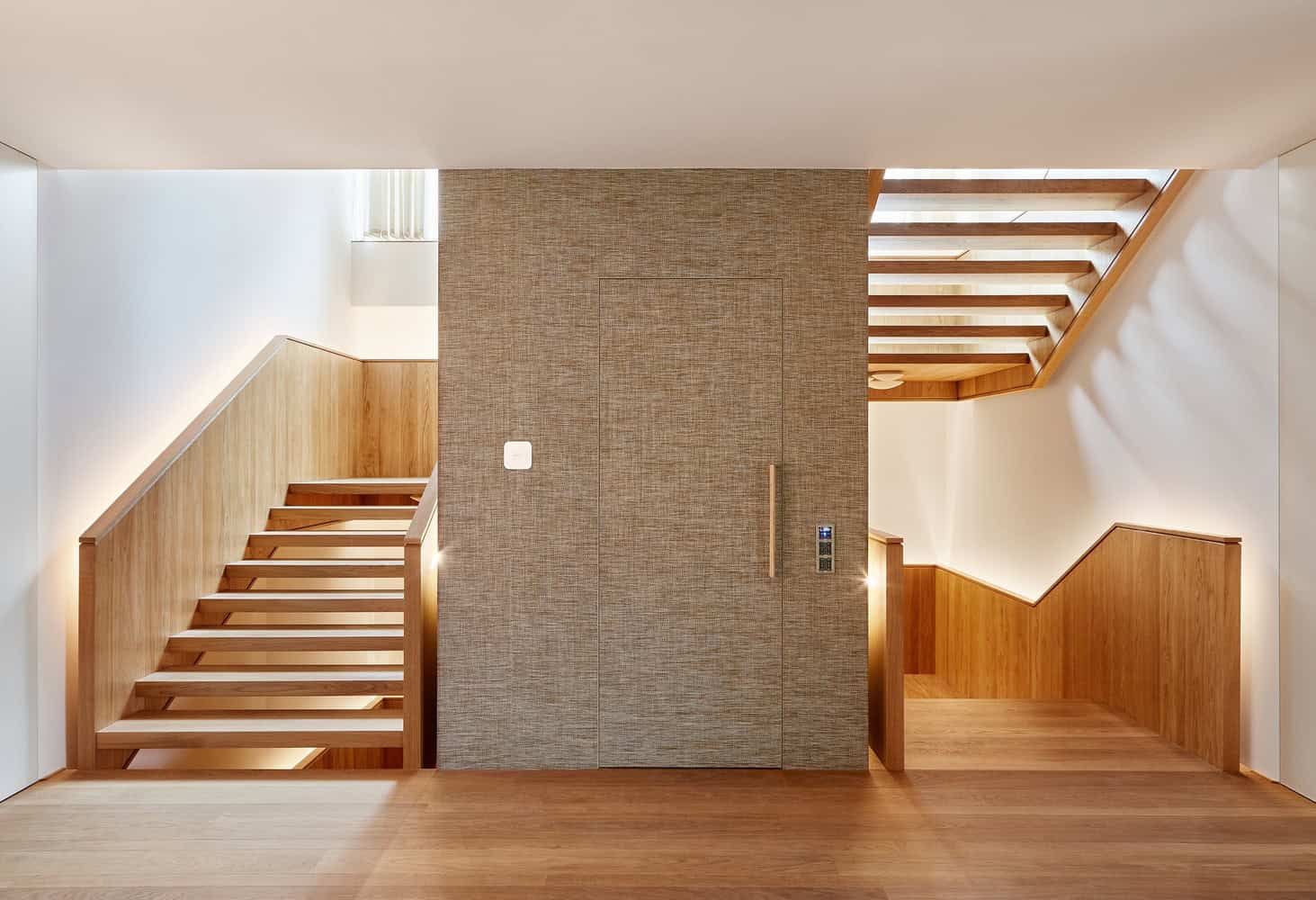 Central staircore at Villa Vista by Znameni Ctyr Architekti in Prague with wood-clad stairs and textured core