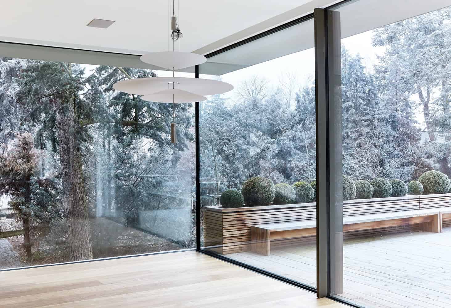 Corner glass walls at Villa Vista by Znameni Ctyr Architekti in Prague overlooking a landscaped terrace