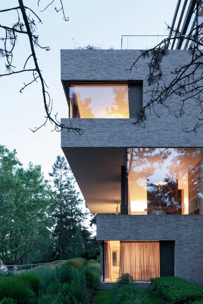 Villa Vista by Znameni Ctyr Architekti, dramatic evening cantilever above dense garden planting
