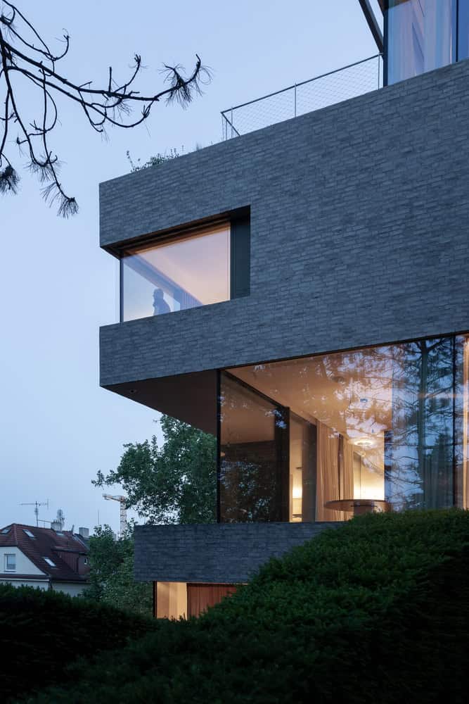 Villa Vista by Znameni Ctyr Architekti, cantilevered corner volume with evening interior light in Prague