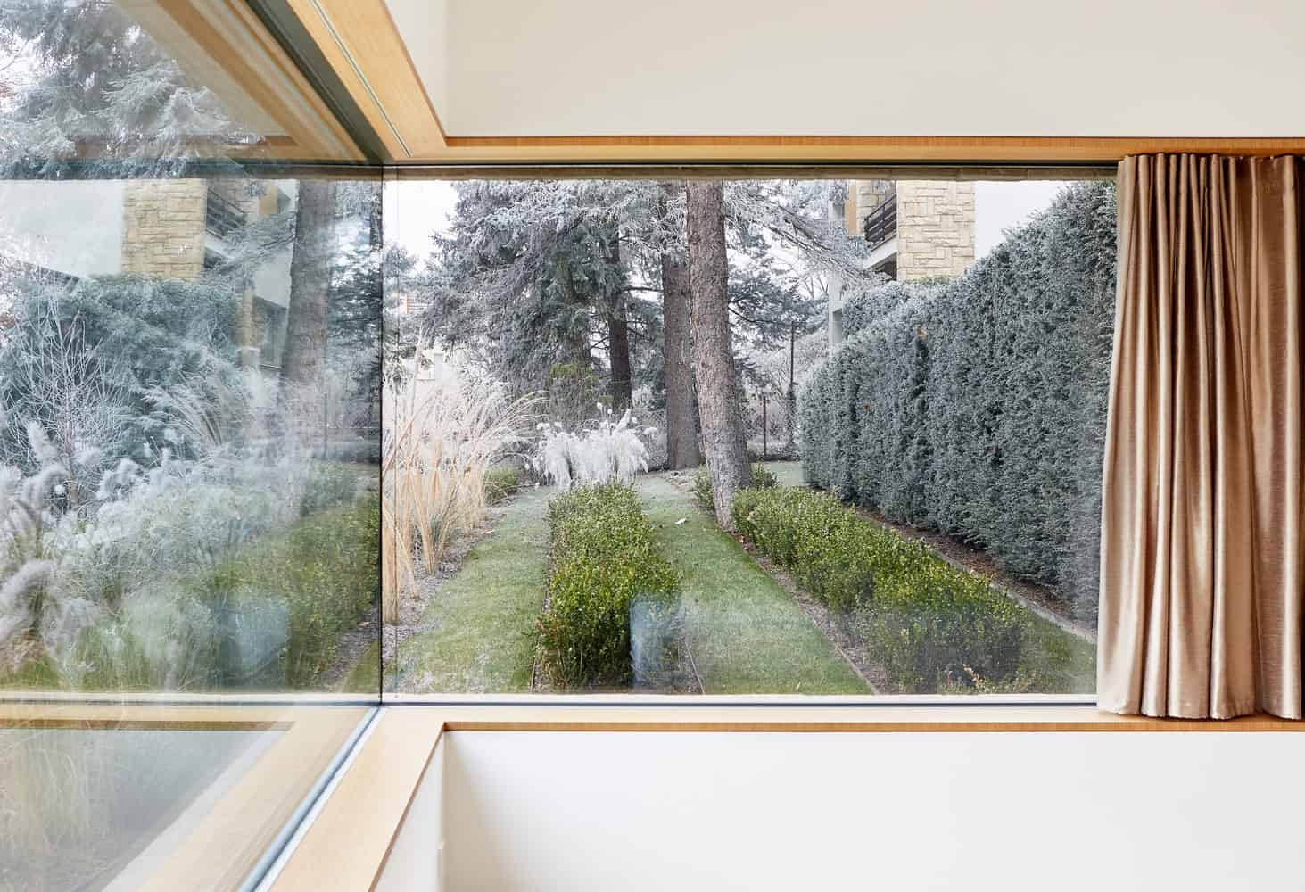 Large framed window at Villa Vista by Znameni Ctyr Architekti in Prague with views of the garden