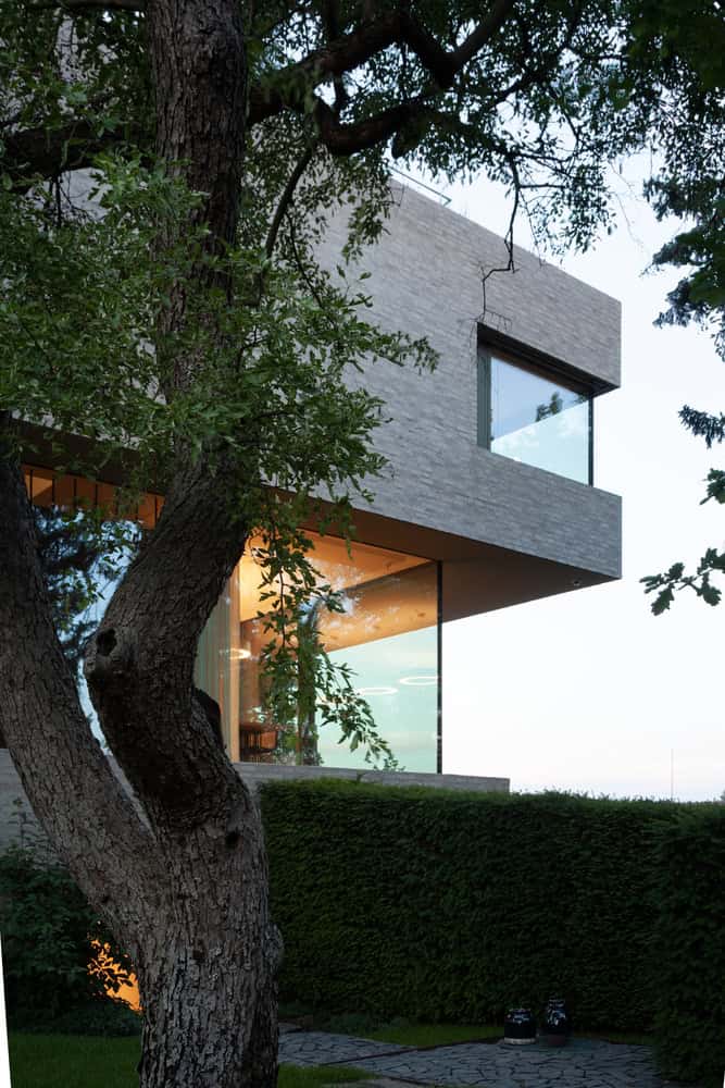 Villa Vista by Znameni Ctyr Architekti, glazed living room opening to garden in Prague