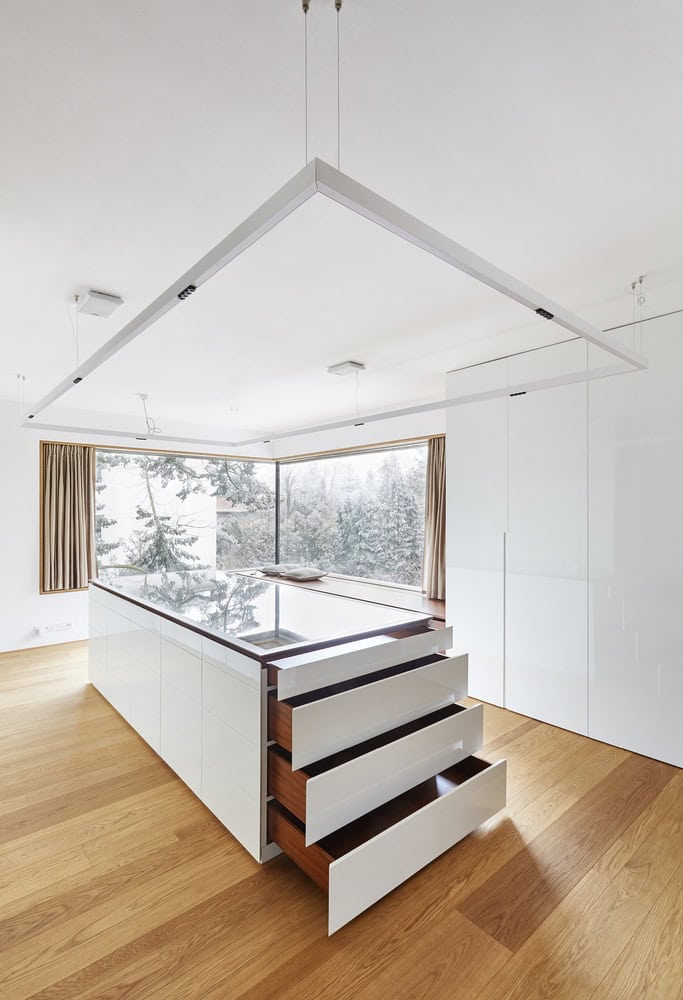 Villa Vista kitchen island with open drawers showing integrated storage by Znameni Ctyr Architekti in Prague