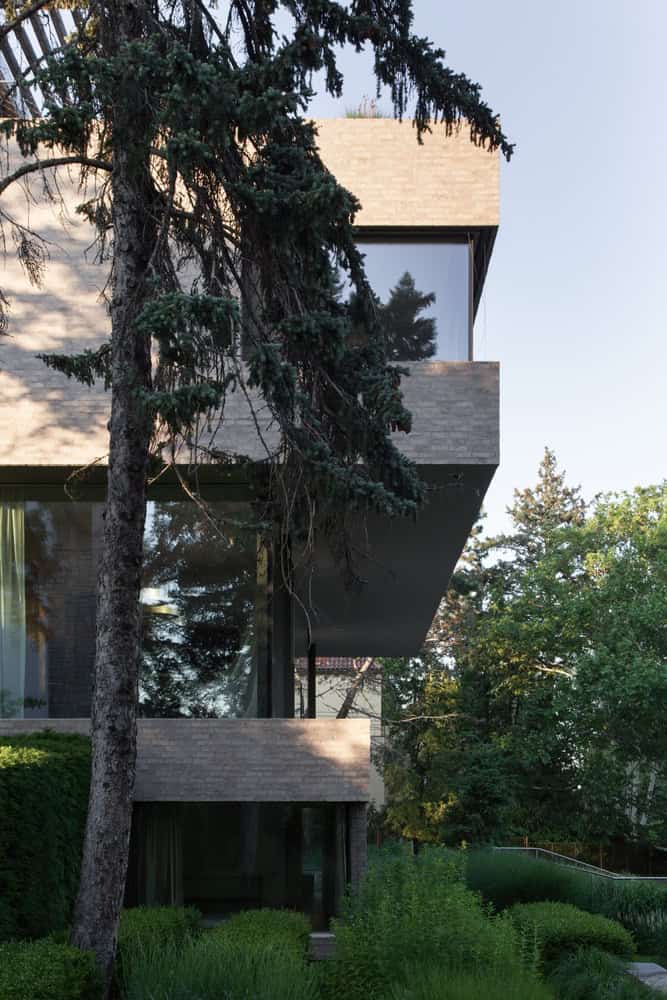 Villa Vista by Znameni Ctyr Architekti, layered side elevation stepping down into lush garden