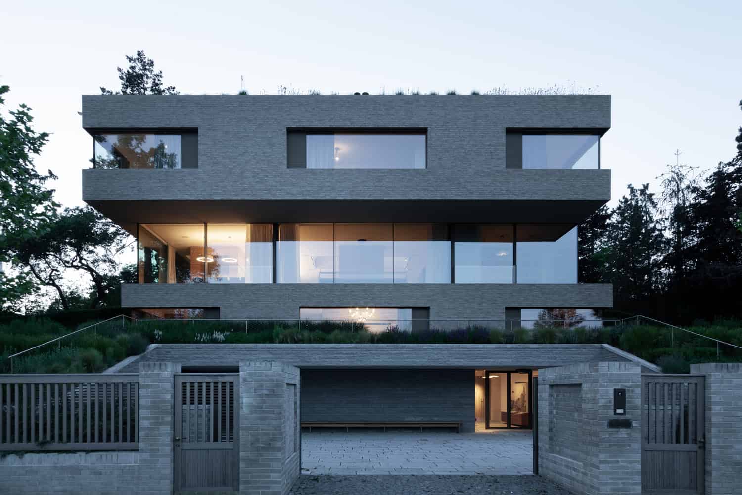 Villa Vista by Znameni Ctyr Architekti, street-facing elevation with brick gate and terraced garden