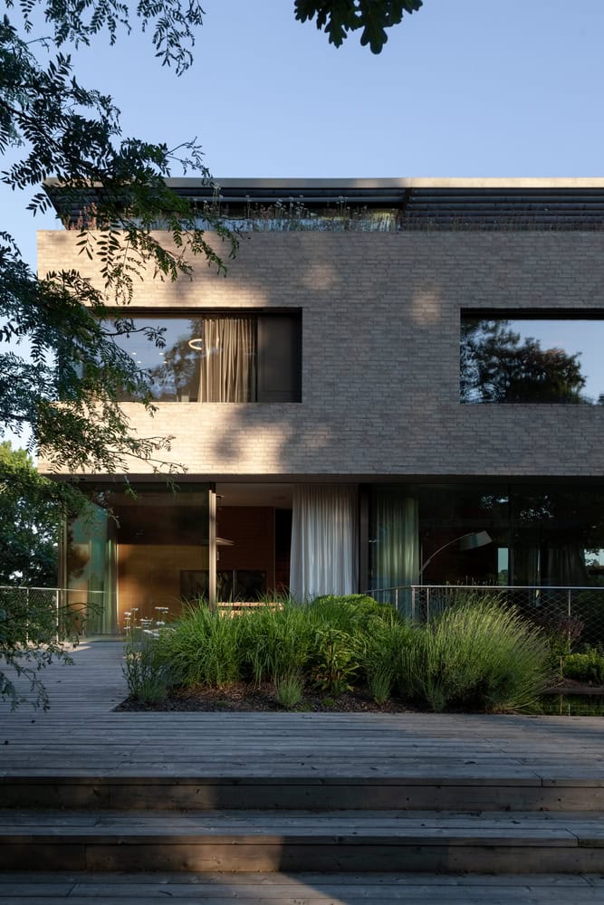 Villa Vista by Znameni Ctyr Architekti, front terrace with layered planting and timber deck